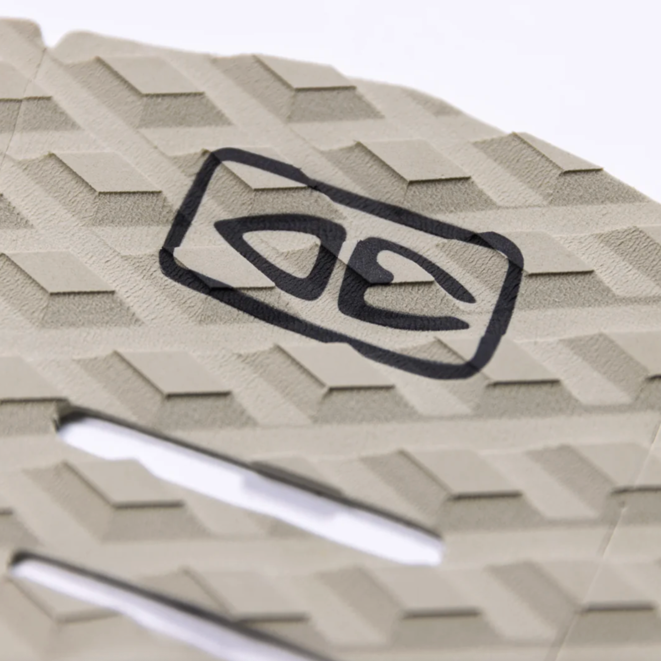 Beige surfboard tail pad with geometric pattern and black logo on a white background