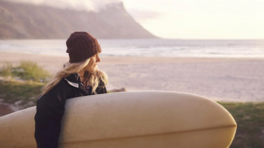 A girl holding her surfboard 