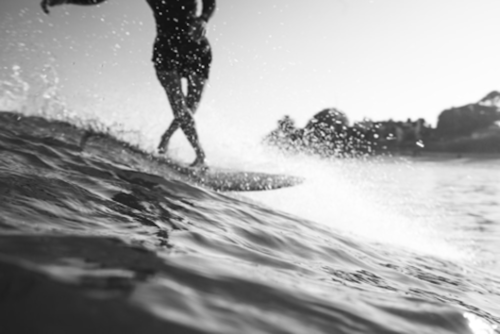 A surfer cross-stepping on their board