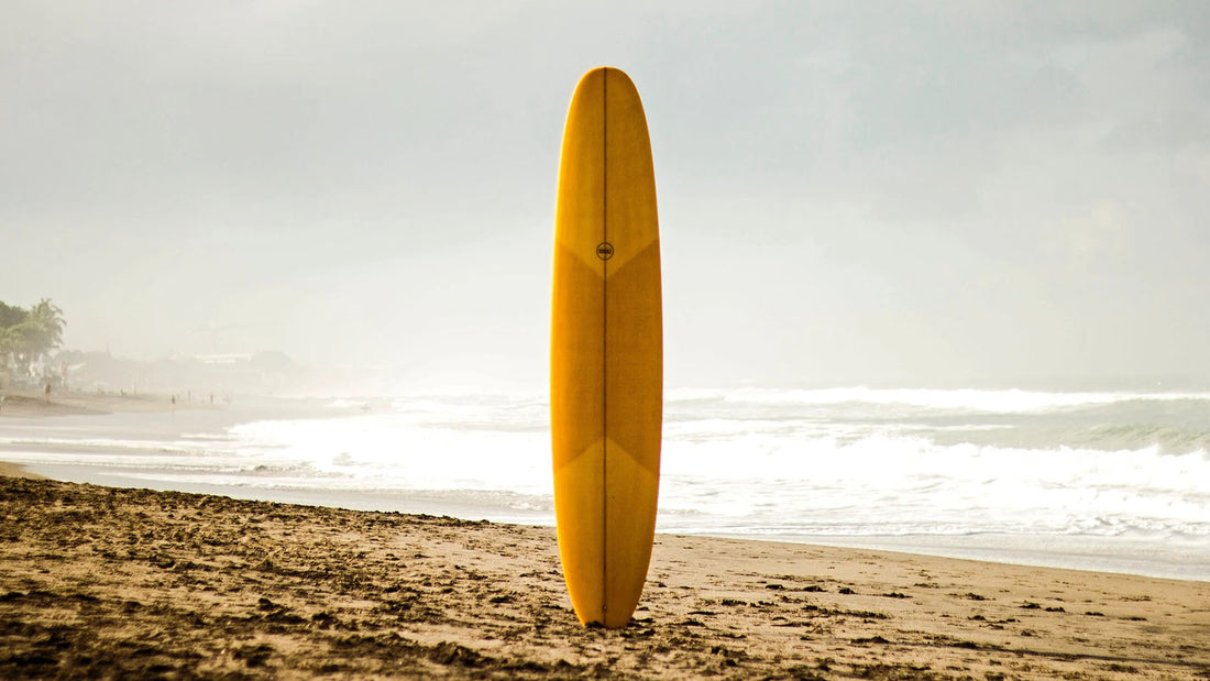 How to Care for Your Surfboard - yellow surfboard on beach