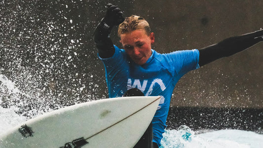 A surfer riding a wave in a wave pool