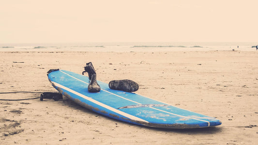 blue surfboard laying on the beach