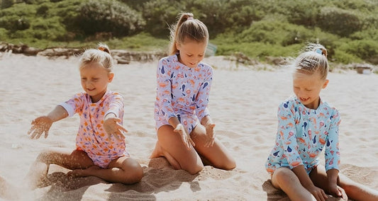 three children playing on beach. Text: 'Ultimate Guide to Buying a Kids' Rash Vest'