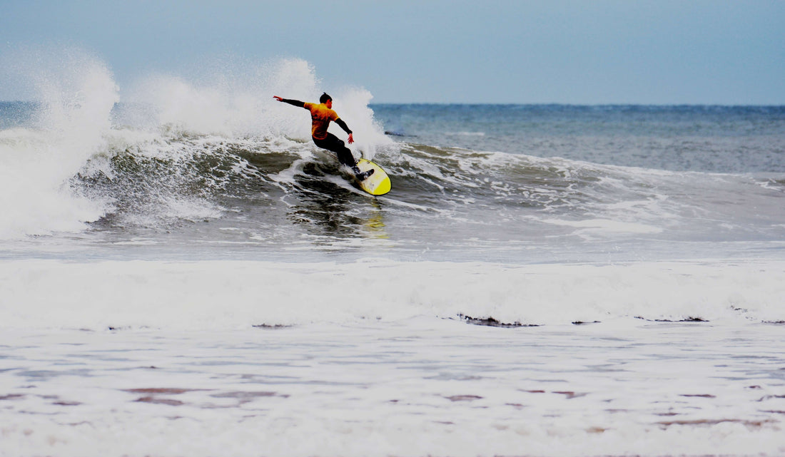 Man surfing a wave on a yellow surfboard