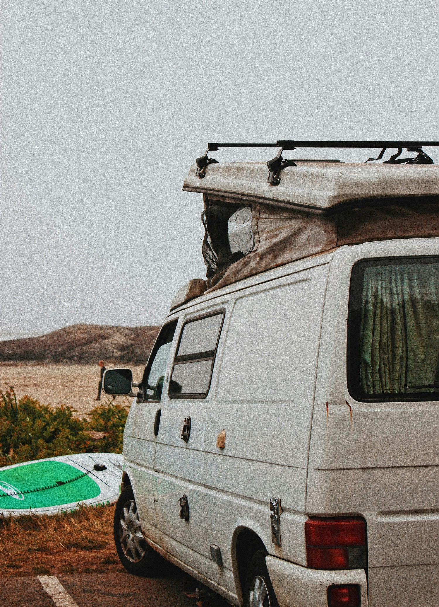 Surf trip with white camper van near beach