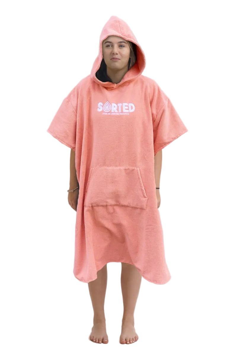 A child model wearing a coral pink hooded changing robe with the text 'SORTED' on the front.
