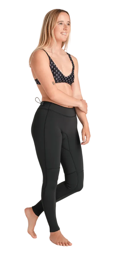 Woman wearing black athletic leggings and sports bra on a white background